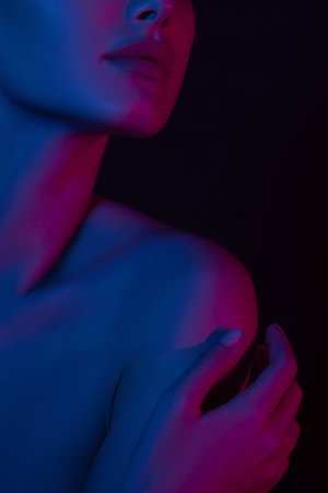 Woman on pink blue neon background. Hands and lips close-up. Anonymous beauty portrait.の写真素材