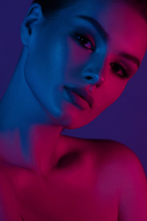 Woman on pink blue neon background. beauty. neon. make up.の写真素材