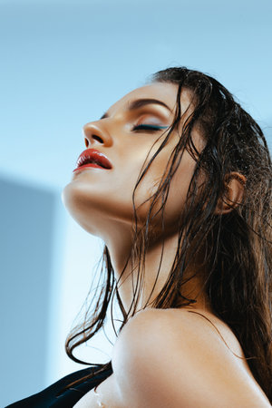 Portrait of caucasian woman with blue arrows and shiny tanned skin in close-up. Wet hair, strong look. beauty and fashion.の写真素材