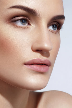 Young Caucasian girl with perfect glowing skin and natural makeup in close-up. beauty and skin careの写真素材