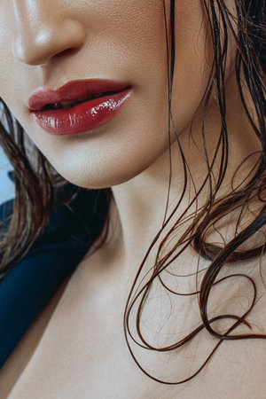Portrait of caucasian woman with blue arrows and shiny tanned skin in close-up. Wet hair, strong look. beauty and fashion.の写真素材