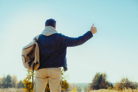 Man is hitchhiking on the background of the road. Travelの写真素材