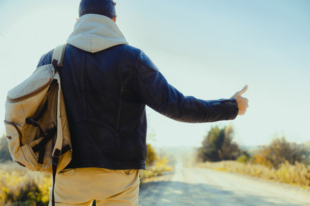 Man is hitchhiking on the background of the road. Travelの写真素材