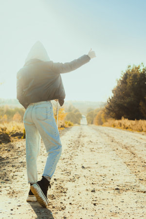Woman is hitchhiking on background of road. Travelの写真素材