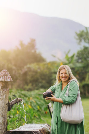 Mature female drinks water from ladle on farm.
