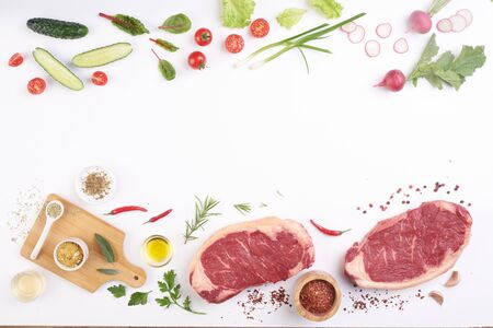 steak on white board with vegetables and spicesの写真素材