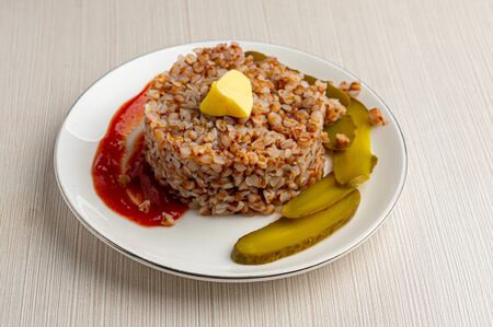 buckwheat with ketchup  and cucumbers on plateの写真素材