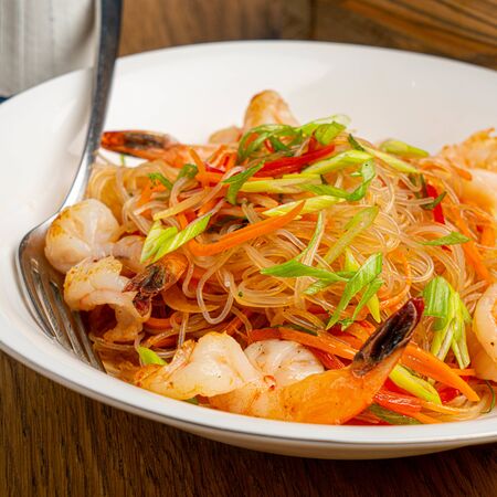 shrimp noodles on fork with vegetablesの写真素材
