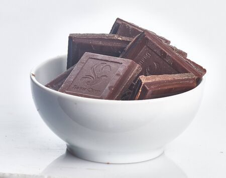 chocolate pieces in white plate  isolatedの写真素材
