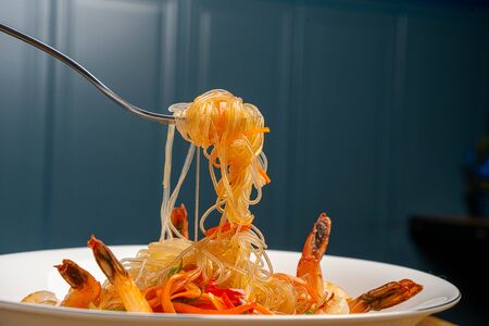shrimp on fork with noodles with vegetables