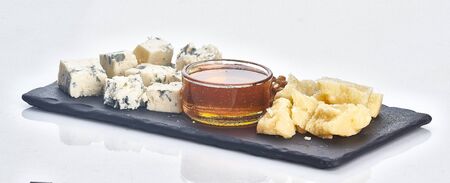 parmesan, blue cheese, walnut and honey on plate isolatedの写真素材