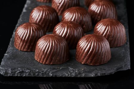 chocolate candies on black stone black backgroundの写真素材