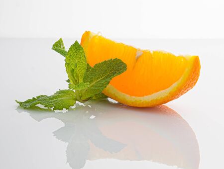 orange slice with mint leaves on white backgroundの写真素材