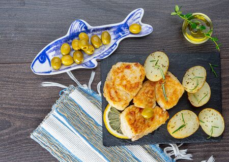 rustic baked cod with potatoes on gray