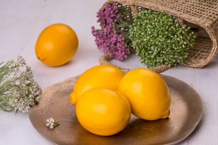 lemons on a copper dish with greensの写真素材