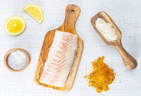 chopped cod on a wooden board on whiteの写真素材