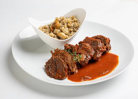 braised beef cheeks on white plateの写真素材