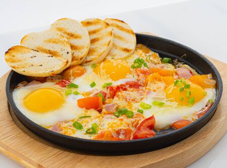 fried eggs with bacon and toast on whiteの写真素材