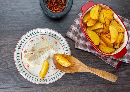 rustic baked cod with potatoes on grayの写真素材