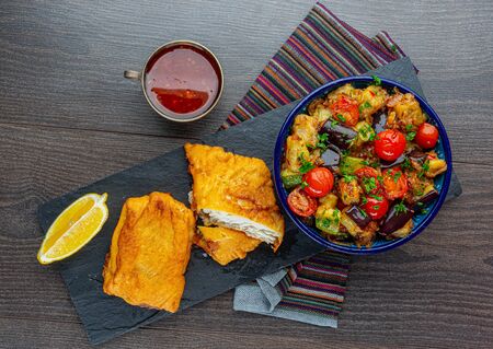 chocolate candies wideep-fried cod with stewed eggplantt white cup on napkinの写真素材