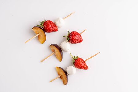 Strawberry with mozzarella on the stud on whiteの写真素材