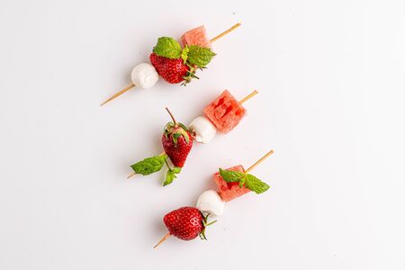 Strawberry with mozzarella and watermelon  on the stud on whiteの写真素材