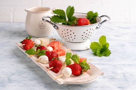 cherry tomatoes with mozzarella balls and watermelons on the stud on whiteの写真素材