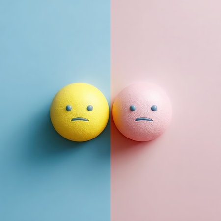 A yellow sphere with a sad face is on light blue, while a pink sphere with a similar sad face rests on pink. They are adjacent to each other, suggesting comparison.の素材