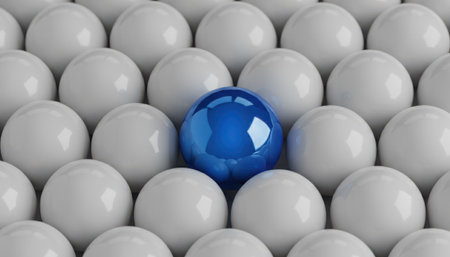 A vivid blue sphere stands prominently amidst a regular arrangement of numerous uniform white spheres. The composition highlights contrast, individuality, and uniqueness, with the single colored ball drawing immediate attention against the monochromatic background. This visual representation conveys concepts of distinction, difference, and being exceptional. The clean, crisp presentation is suitable for various conceptual themes.の素材