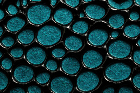 A detailed close-up of a vibrant teal textured surface. Numerous raised, rounded elements, resembling scales or bubbles, are set against a dark background, creating an abstract and organic pattern. The surface has a subtle metallic sheen.の素材