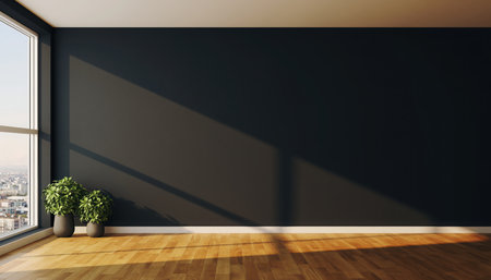 A bright, empty modern interior space featuring a stark dark accent wall contrasting with a warm-toned wooden floor. Large, floor-to-ceiling windows on the left allow abundant natural light to flood the room, creating prominent diagonal shadows across the wall and floor. Two small green potted plants sit near the window, providing a subtle touch of nature. The room, with its clean lines and minimalist aesthetic, offers a serene and versatile backdrop, suggesting possibilities for new design projects, renovation, or a blank canvas for living.の素材