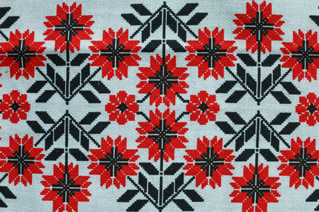 Delicate red flowers burst forth from a backdrop of intricate black patterns, showcasing traditional...