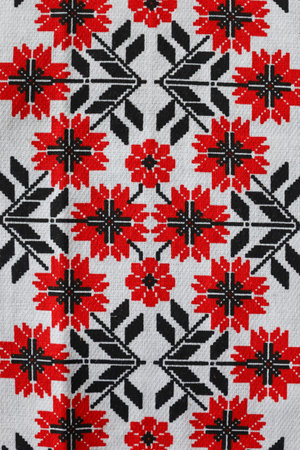 Colorful textile features an intricate arrangement of flowers and geometric shapes.