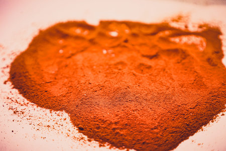 A cloud of fine red spice lies on a smooth surface, inviting chefs to create culinary wonders. Its rich color hints at the bold taste ready to enhance any dish.の写真素材