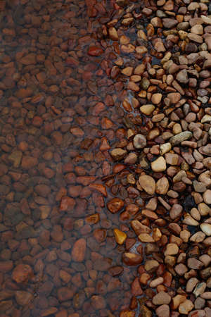 water and brown stones at lake shore no people conceptual texture copy spaceの写真素材