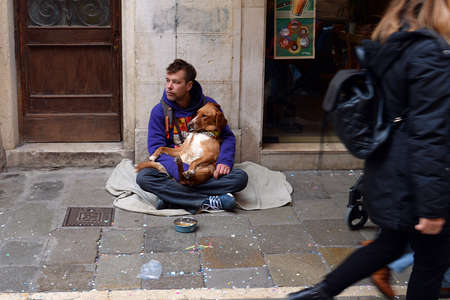 Venice, Itay 02 12 2017: homeless beggar man with dog on venetian treet during carnivalのeditorial素材