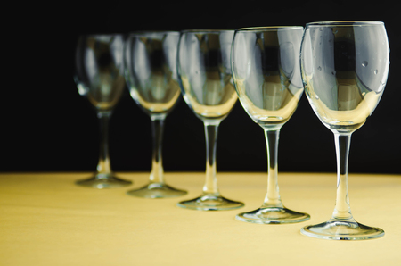Wine glasses on black and yellow background for textの写真素材