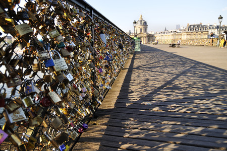 Lovers have locked thousands of locks to the Pont des Arts bridge in Paris. The padlocks, with keys thrown into the Seine River, is a modern traditionのeditorial素材