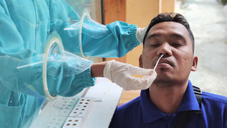 KOLAKA, INDONESIA - September, 2021: Lab technicians wearing PPE took nasopharyngeal swab samples...