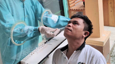 KOLAKA, INDONESIA - September, 2021: Lab technicians wearing PPE took nasopharyngeal swab samples...