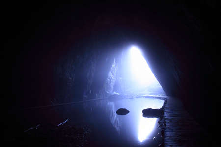 entrance in cave as border between light and darknes の写真素材