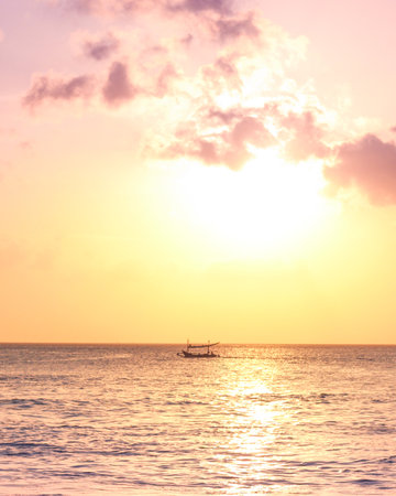 Beautiful sunset over the sea with a boat in the foreground.の写真素材