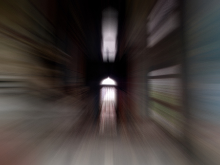 A dark tunnel having one source of light.Shot with motion blur effect.の写真素材