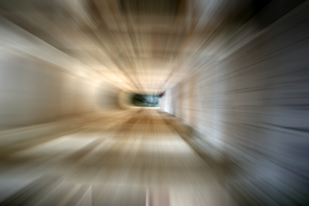A dark tunnel having one source of light.Shot with motion blur effect.の写真素材