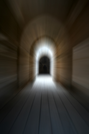 A dark tunnel having one source of light.Shot with motion blur effect.の写真素材