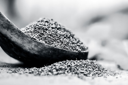 Trachyspermum ammi, Ajwain seeds in a wooden scoop with some leaves on a gunny background.の写真素材