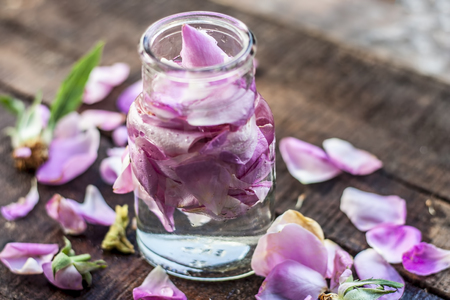 A transparent bottle contains rose water with rose petals in it.Concept of beauty and care.の写真素材
