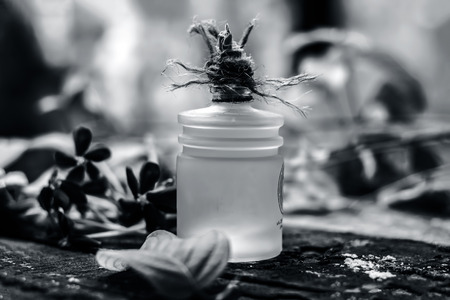 Combretum indicum,Rangoon creeper's oil in a glass bottle on rustic wooden surface with it's flowers.の写真素材