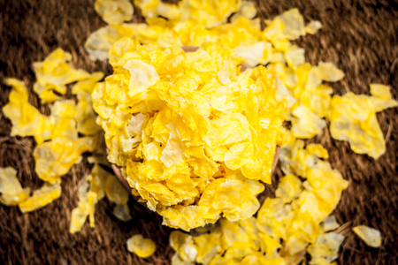 Zea mays,Maize flakes in a clay bowl on a gunny background.
