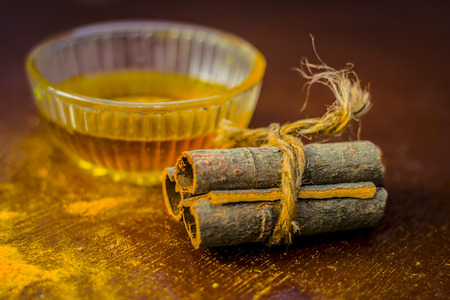 Water of cinnamon,Cinnamomum zeylanicum in a glass bowl on wooden surface.の写真素材
